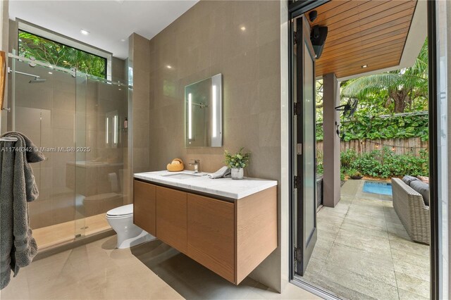 2803 Crystal Ct, Coconut Grove, FL 33133 - full bathroom with a stall shower, vanity, toilet, tile walls, and healthy amount of natural light