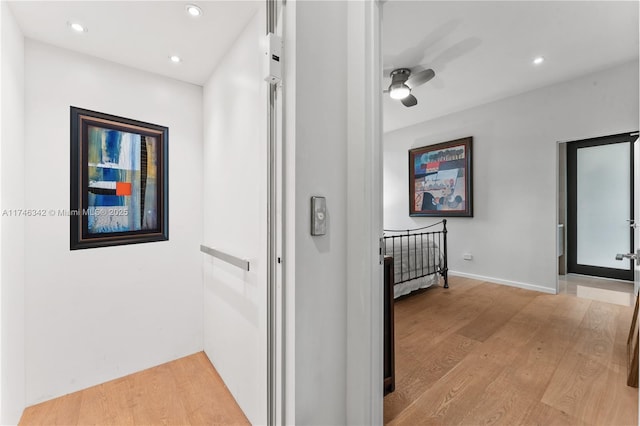 corridor with an upstairs landing, recessed lighting, baseboards, and light wood-style floors