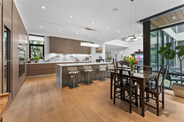 dining space featuring a wall of windows, recessed lighting, and light wood-type flooring