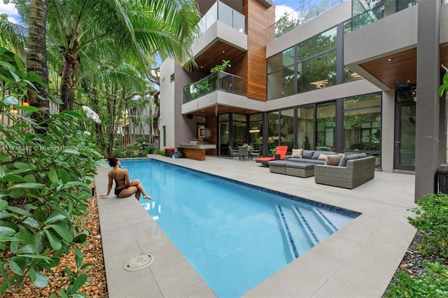 outdoor pool with an outdoor living space and a patio