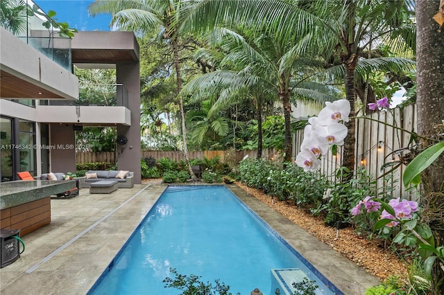 view of swimming pool featuring an outdoor living space, a fenced backyard, a fenced in pool, and a patio