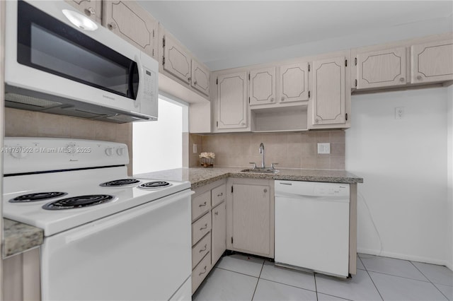 kitchen with a sink, white appliances, backsplash, and light tile patterned floors