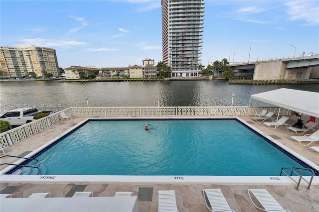 community pool featuring a water view, a view of city, and a patio area