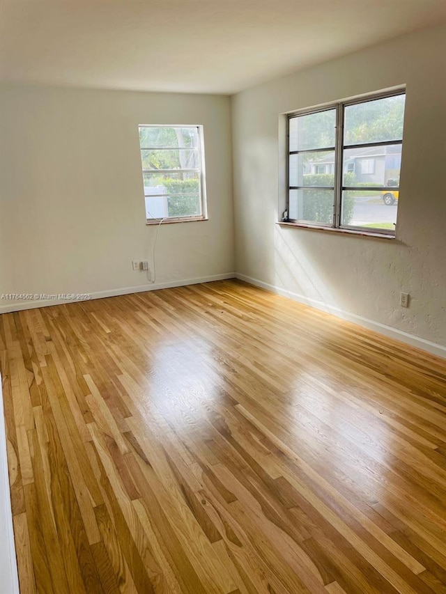 spare room featuring light wood finished floors and baseboards