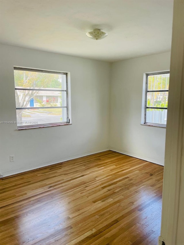 unfurnished room featuring wood finished floors and a wealth of natural light