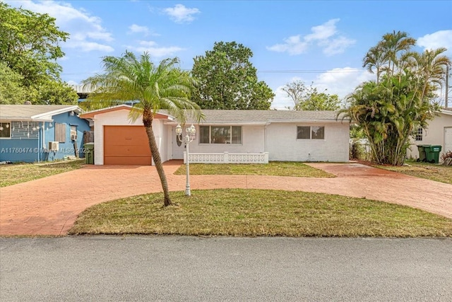 single story home featuring an attached garage, decorative driveway, and a front lawn