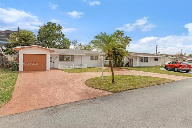 ranch-style house featuring a front yard, fence, a garage, and curved driveway