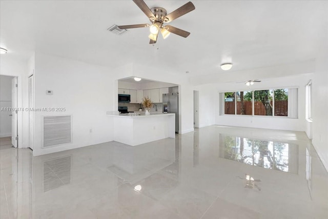 unfurnished living room with visible vents and a ceiling fan