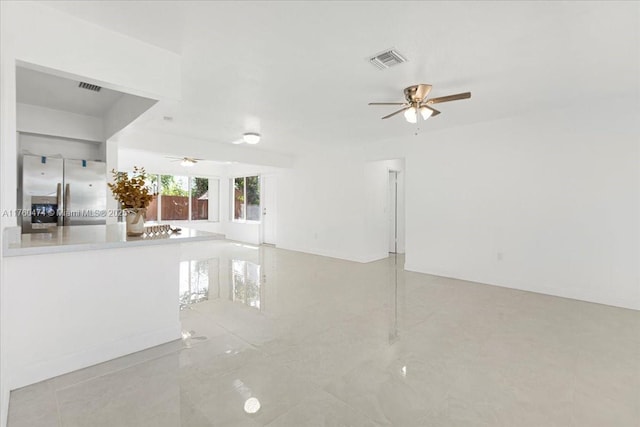 unfurnished living room featuring visible vents and ceiling fan