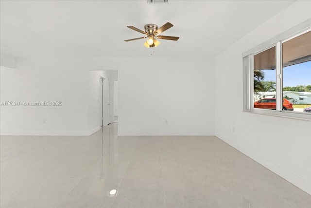 spare room with visible vents, baseboards, and a ceiling fan