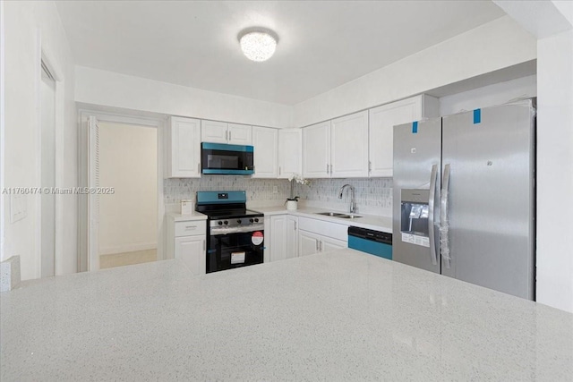 kitchen with decorative backsplash, white cabinetry, stainless steel appliances, and a sink