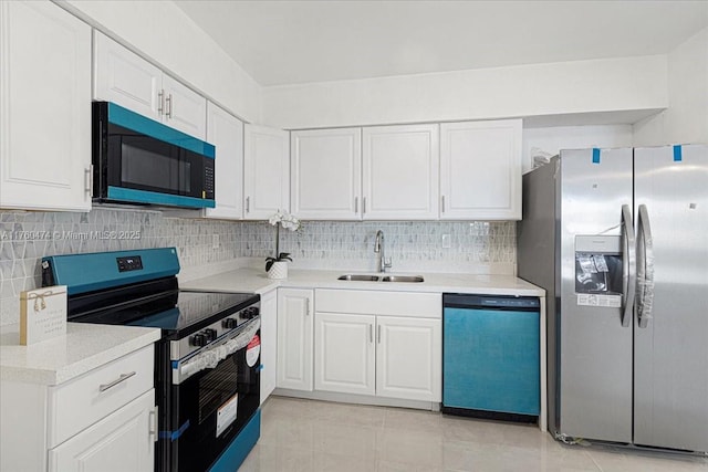 kitchen featuring tasteful backsplash, white cabinets, appliances with stainless steel finishes, and a sink