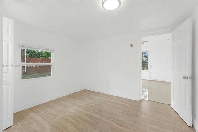 empty room featuring baseboards, plenty of natural light, and wood finished floors