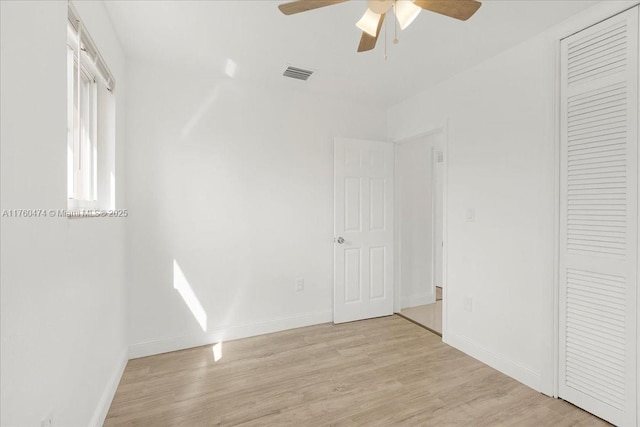 unfurnished bedroom with a closet, visible vents, baseboards, and light wood-style floors