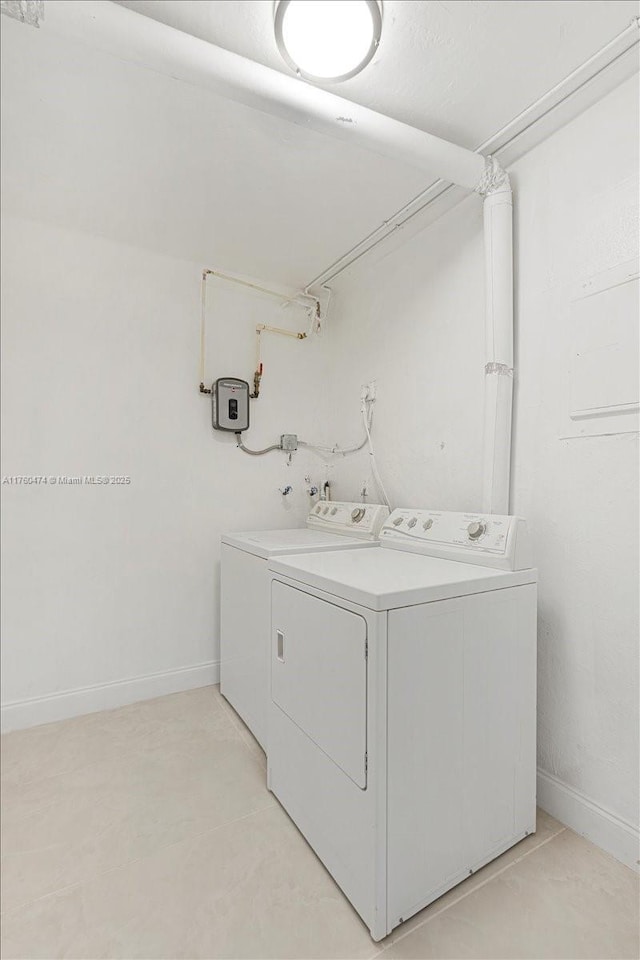 washroom featuring baseboards, laundry area, and washer and clothes dryer