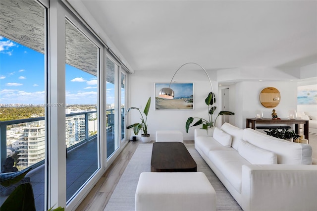 living room featuring a wall of windows and light wood-style flooring