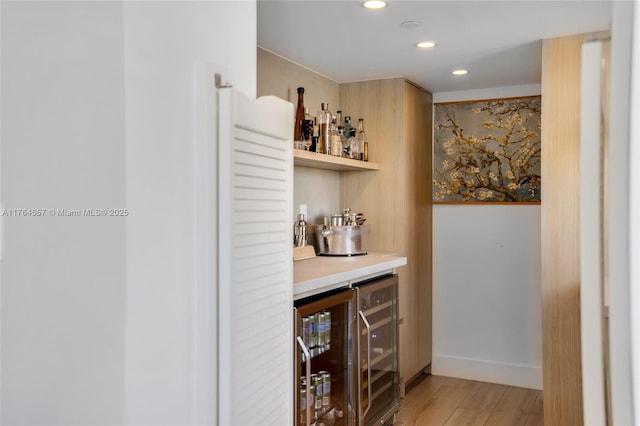 bar with recessed lighting, beverage cooler, a dry bar, and light wood finished floors