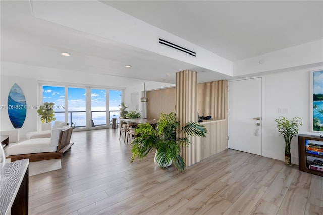 interior space featuring light wood-style flooring, recessed lighting, and visible vents