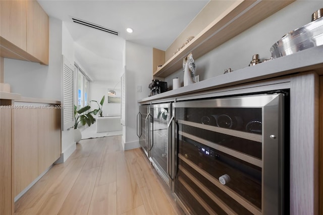 kitchen with wine cooler, modern cabinets, visible vents, and light wood finished floors