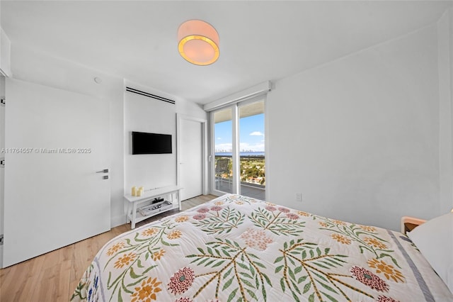 bedroom featuring wood finished floors and access to exterior