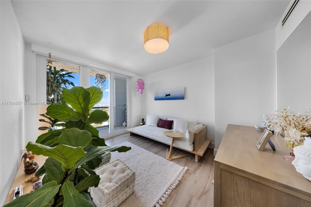 living area with visible vents and wood finished floors