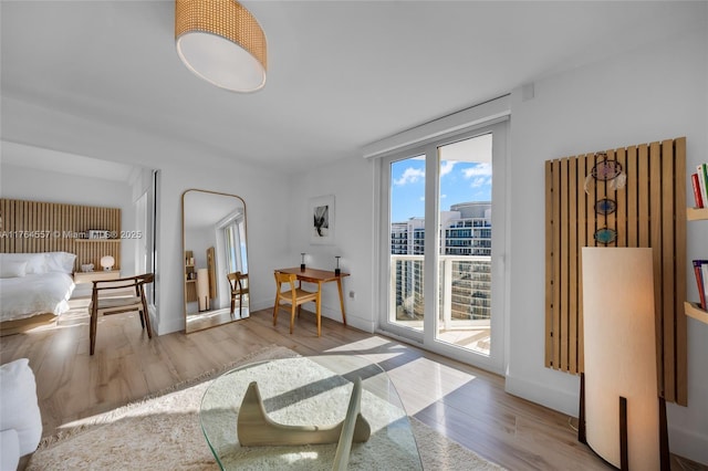 living area featuring a city view, baseboards, and wood finished floors