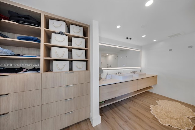 bathroom with recessed lighting, visible vents, wood finished floors, and vanity