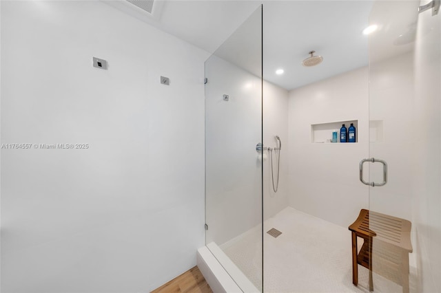 bathroom featuring visible vents, a shower stall, and wood finished floors