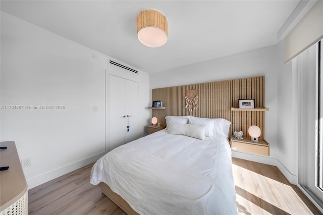 bedroom featuring a closet, baseboards, and wood finished floors