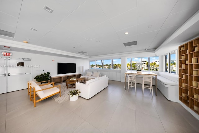 tiled living room with a tray ceiling, visible vents, and a drop ceiling