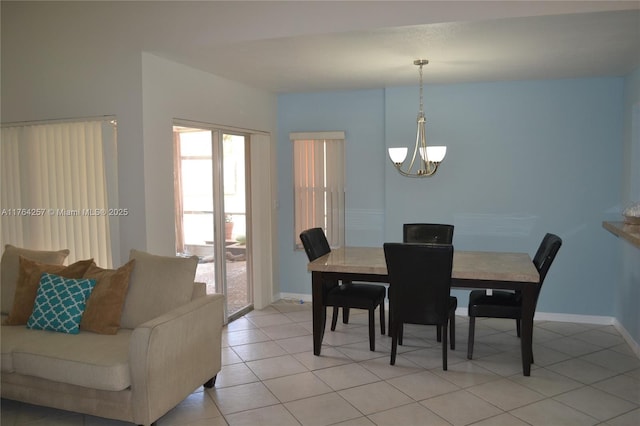 dining area with light tile patterned floors, baseboards, and a chandelier