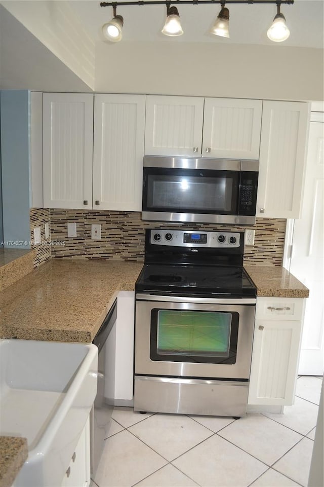 kitchen featuring white cabinets, light tile patterned floors, backsplash, and stainless steel appliances