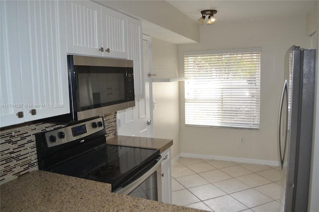 kitchen featuring decorative backsplash, light tile patterned floors, white cabinetry, and stainless steel appliances