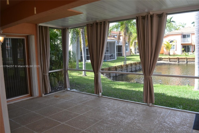 unfurnished sunroom featuring a water view and a wealth of natural light