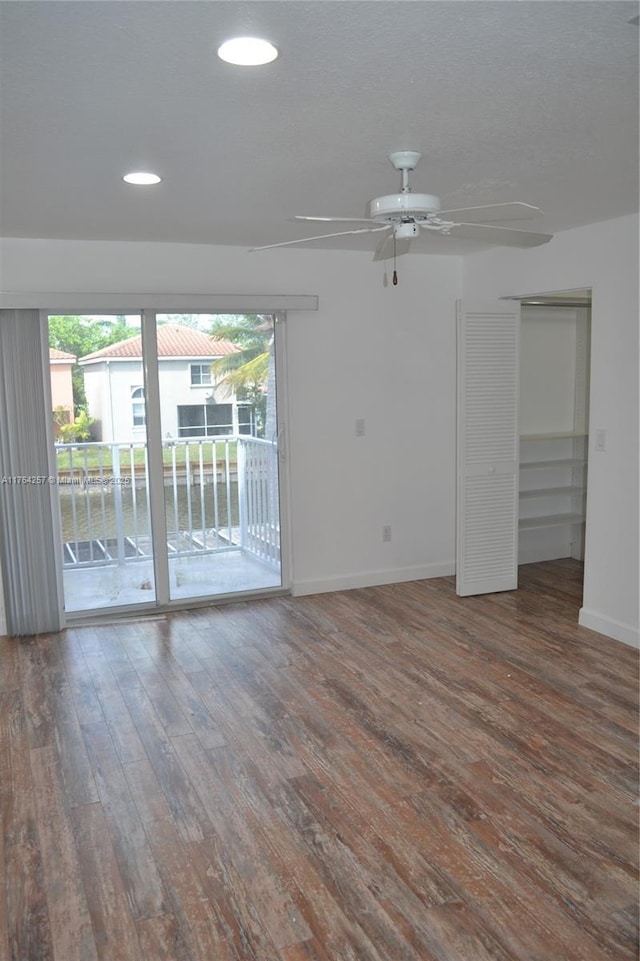 empty room featuring a ceiling fan, recessed lighting, wood finished floors, and baseboards