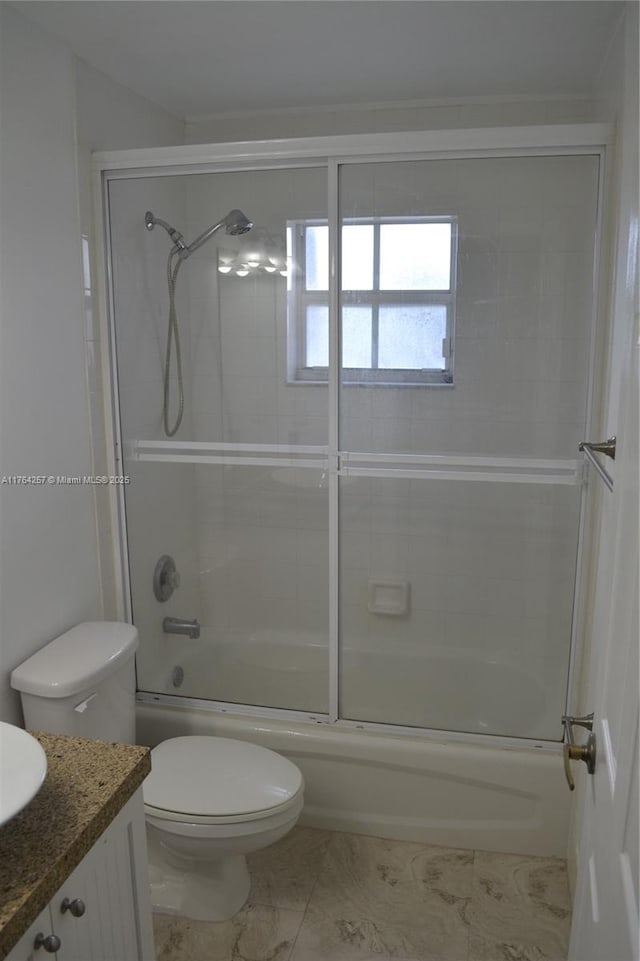 bathroom featuring combined bath / shower with glass door, toilet, and vanity