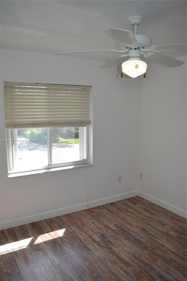 spare room featuring baseboards, a ceiling fan, and wood finished floors