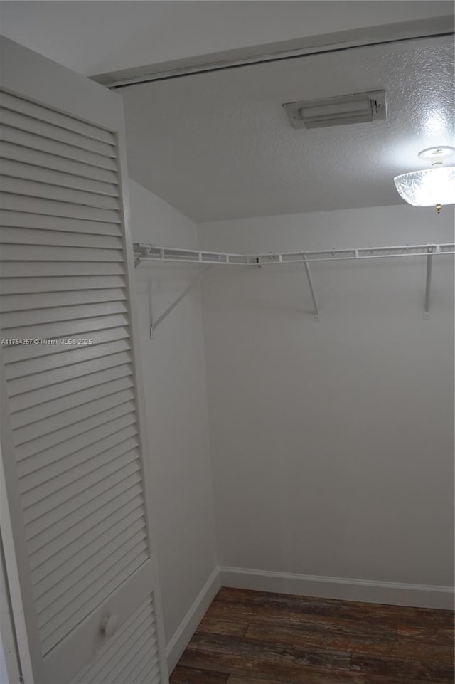 walk in closet featuring dark wood-style floors