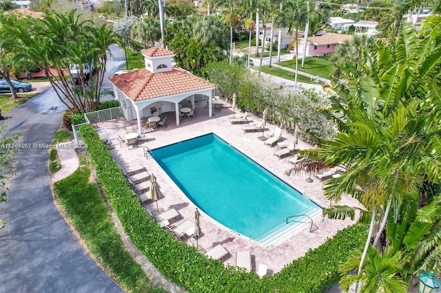 community pool with a gazebo, a patio area, and fence