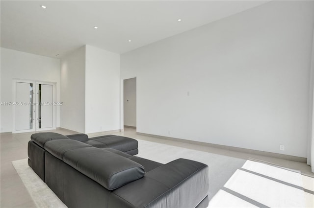 living room with recessed lighting, french doors, and a towering ceiling