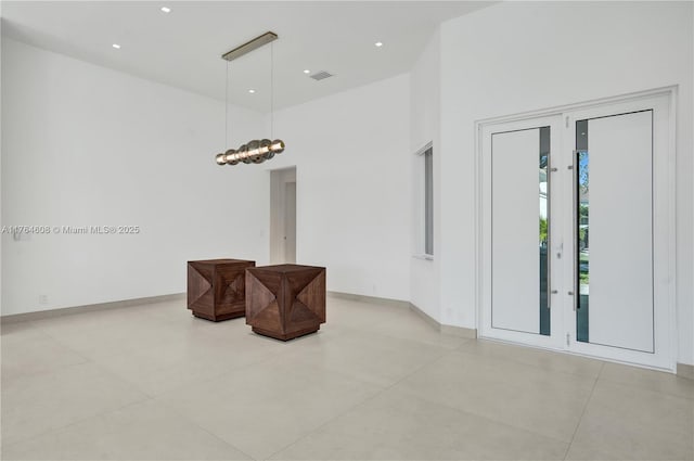 interior space featuring recessed lighting, visible vents, baseboards, and a high ceiling