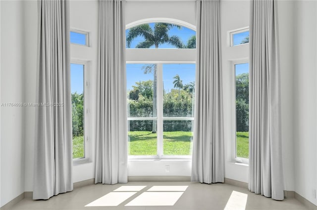 doorway to outside featuring a high ceiling and baseboards