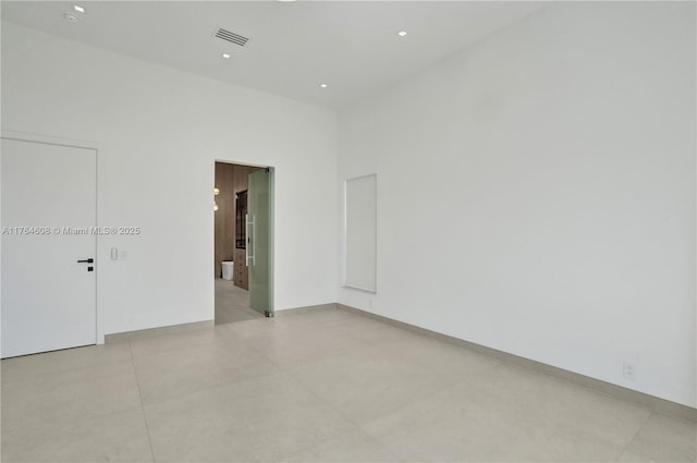 empty room featuring recessed lighting, visible vents, and baseboards