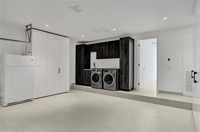 clothes washing area featuring washer and dryer, recessed lighting, and laundry area