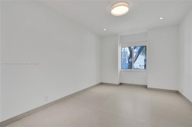 unfurnished room with baseboards