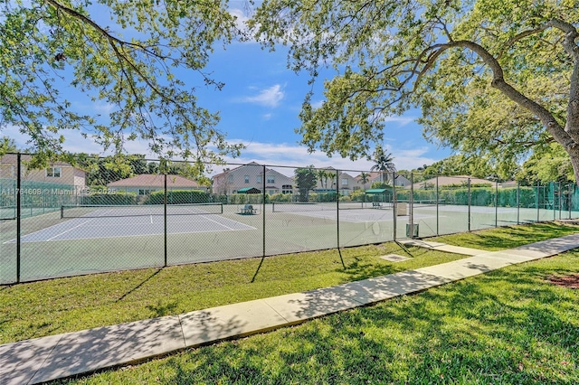 view of sport court featuring a residential view, a lawn, and fence