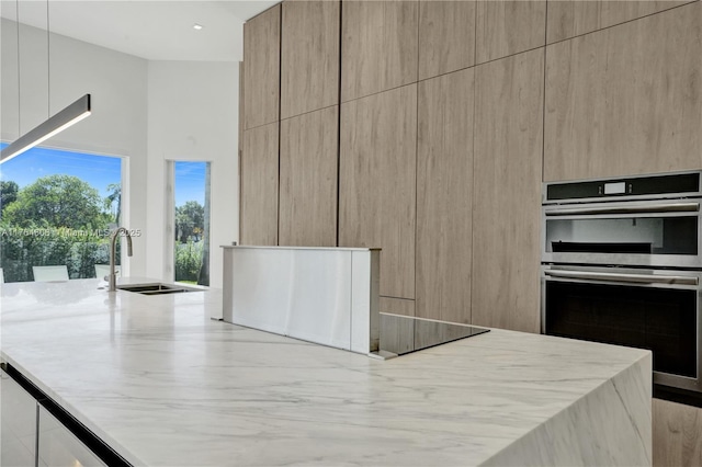 3234 SW 53rd Ct, Hollywood, FL 33312 - kitchen with modern cabinets, stainless steel double oven, a high ceiling, a sink, and light stone counters