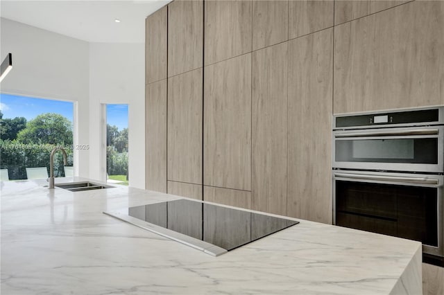 3234 SW 53rd Ct, Hollywood, FL 33312 - kitchen with modern cabinets, black electric stovetop, light stone countertops, and a sink