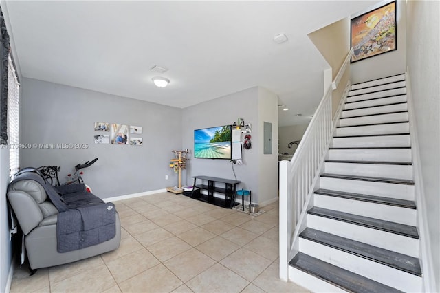 living room featuring stairway, light tile patterned floors, and baseboards