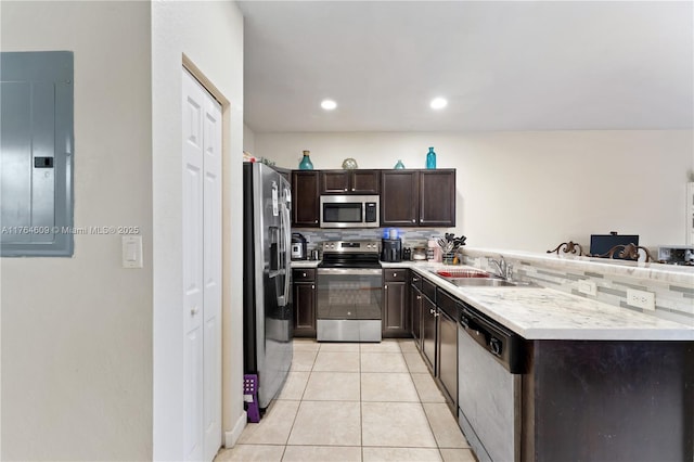 kitchen with a sink, electric panel, stainless steel appliances, dark brown cabinetry, and light tile patterned floors